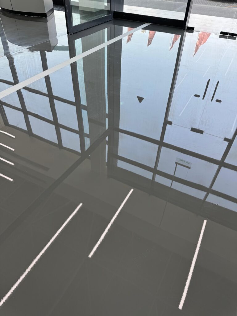 Floor layout markings near corner glazing before epoxy self-level installation, Dubai site